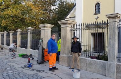 Hausmeister Manfred Paukner und Steinmetz Matthias Gebel bei der Sanierung des historischen Friedhofzauns