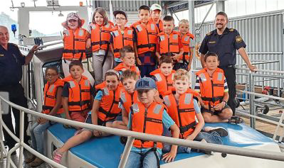 Polizisten der Wasserschutzpolizei mit den Kindern auf dem Einsatzboot