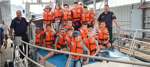 Polizisten der Wasserschutzpolizei mit den Kindern auf dem Einsatzboot