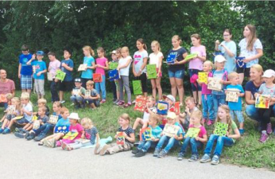 Kinder mit ihren selbstgestalteten Holzbildern