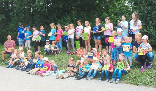 Kinder mit ihren selbstgestalteten Holzbildern