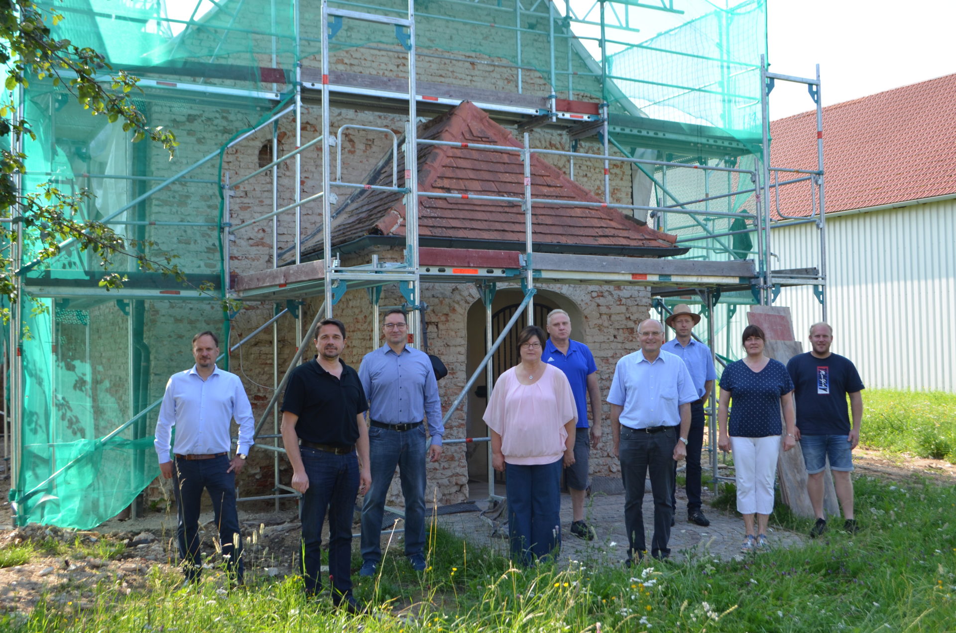 1. Bürgermeister Adalbert Hösl (2. v.l.), 3. Bürgermeisterin Heike Kattler (Mitte) und Gemeinderat Florian Eckl (rechts), zusammen mit Pfarrer Johann Christian Rahm (4. v.r.), Architekt Alexander Weny (links), und den Mitgliedern der Kirchenverwaltung Niederharthausen.