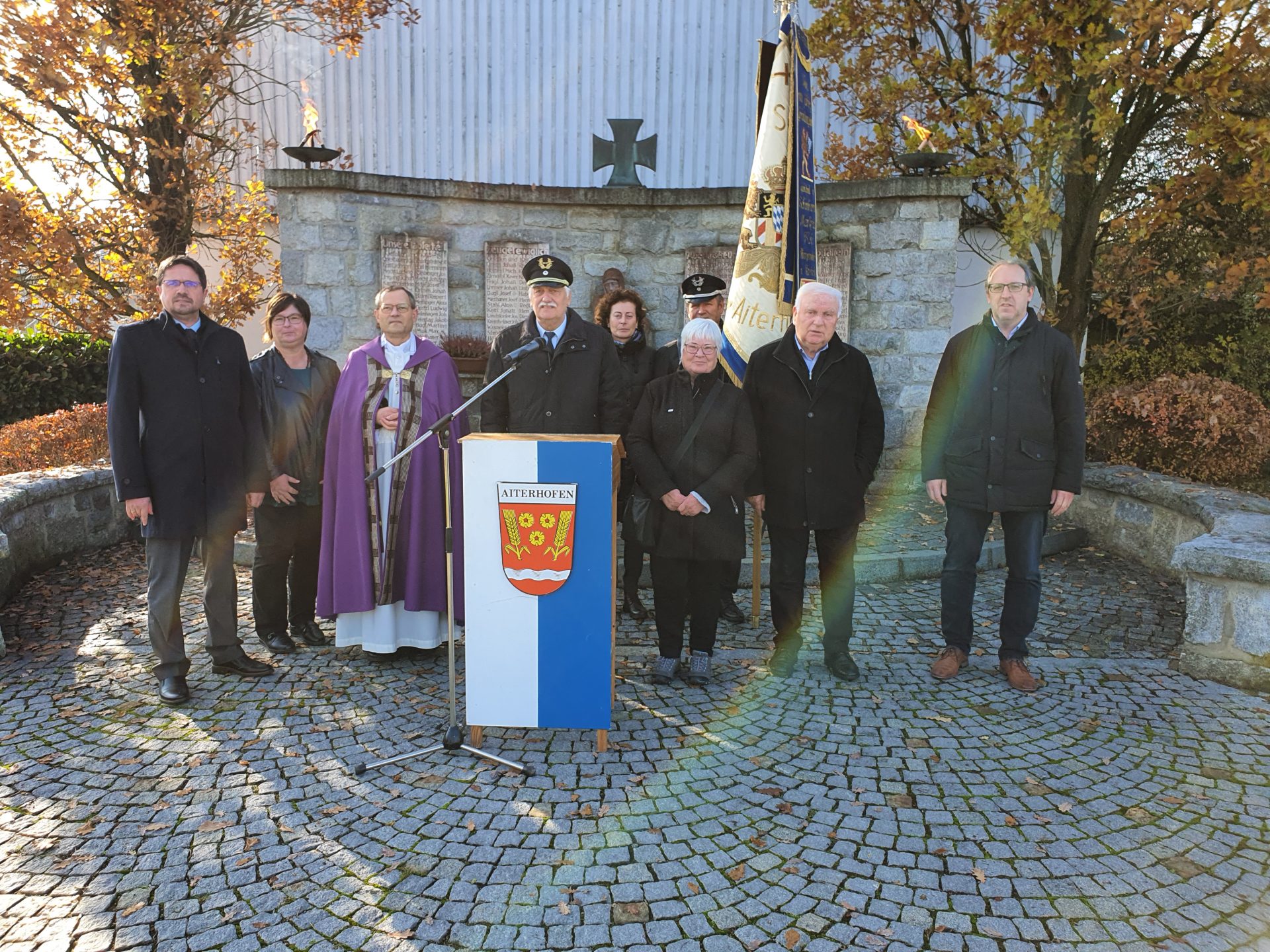 BGM Adalbert Hösl, 3. Bürgermeisterin Heike Kattler, Pfarrer Heinrich Weber, KSV-Vorsitzender Ernst Limmer, Festfrau des KSV Gabriele Buchner, stellv. Vorsitzender Norbert Buchner, VDK-Vorsitzende Marianne Wahl, Altbürgermeister Manfred Krä, stellv. Bürgermeister Manfred Engl am Kriegerdenkmal in Aiterhofen.